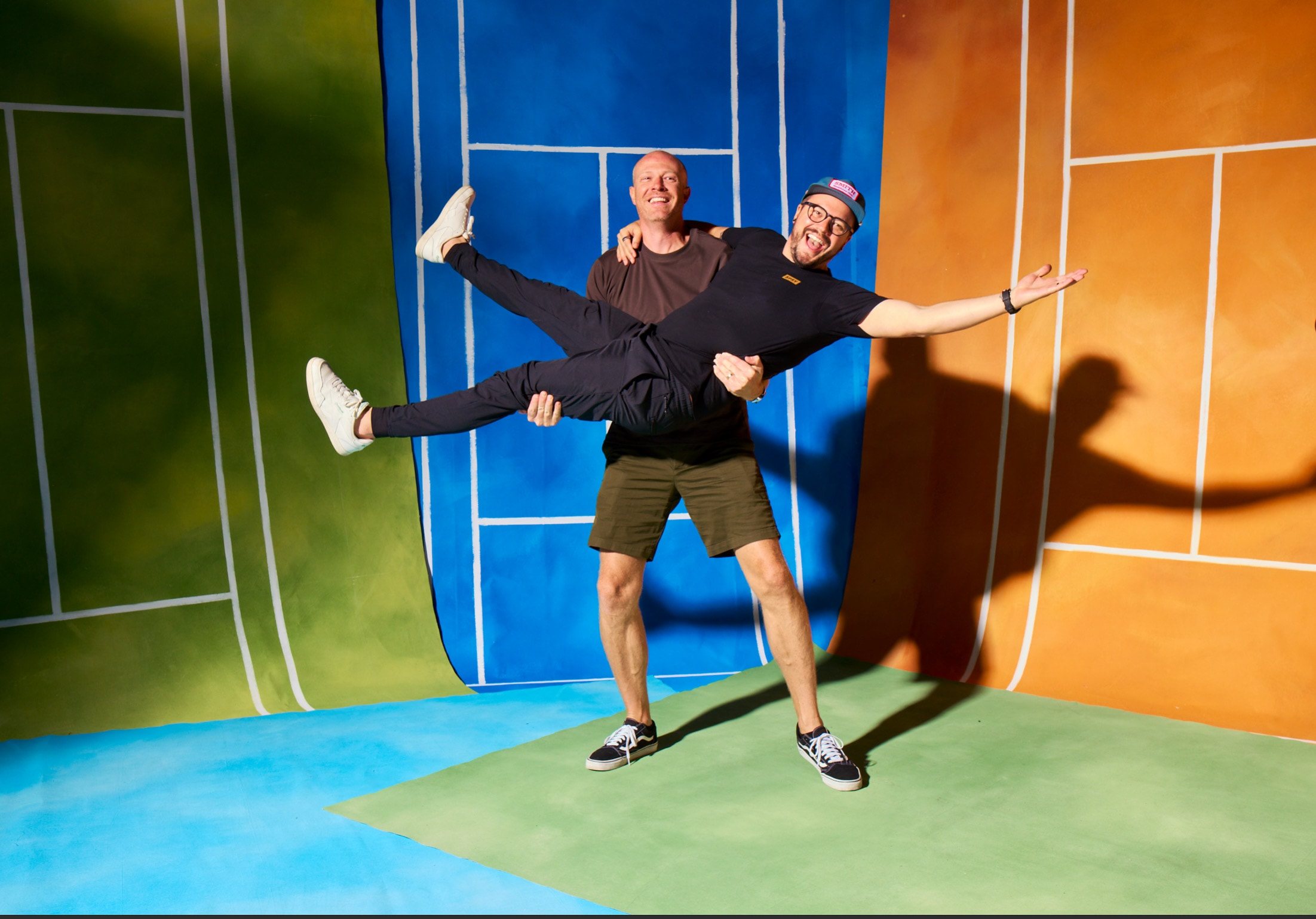 Two of the crew strike a pose in front of the painted court backdrops