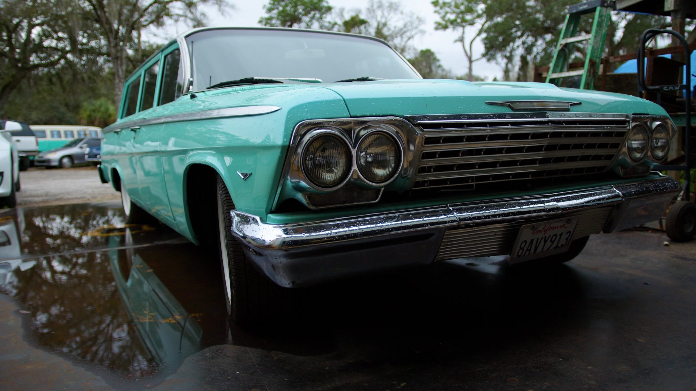 Chrome grille and quad headlights of a teal Bel Air wagon