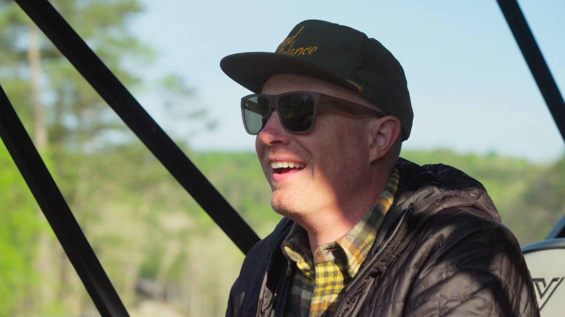Derek Miller laughing at the wheel of a boat on Smith Lake