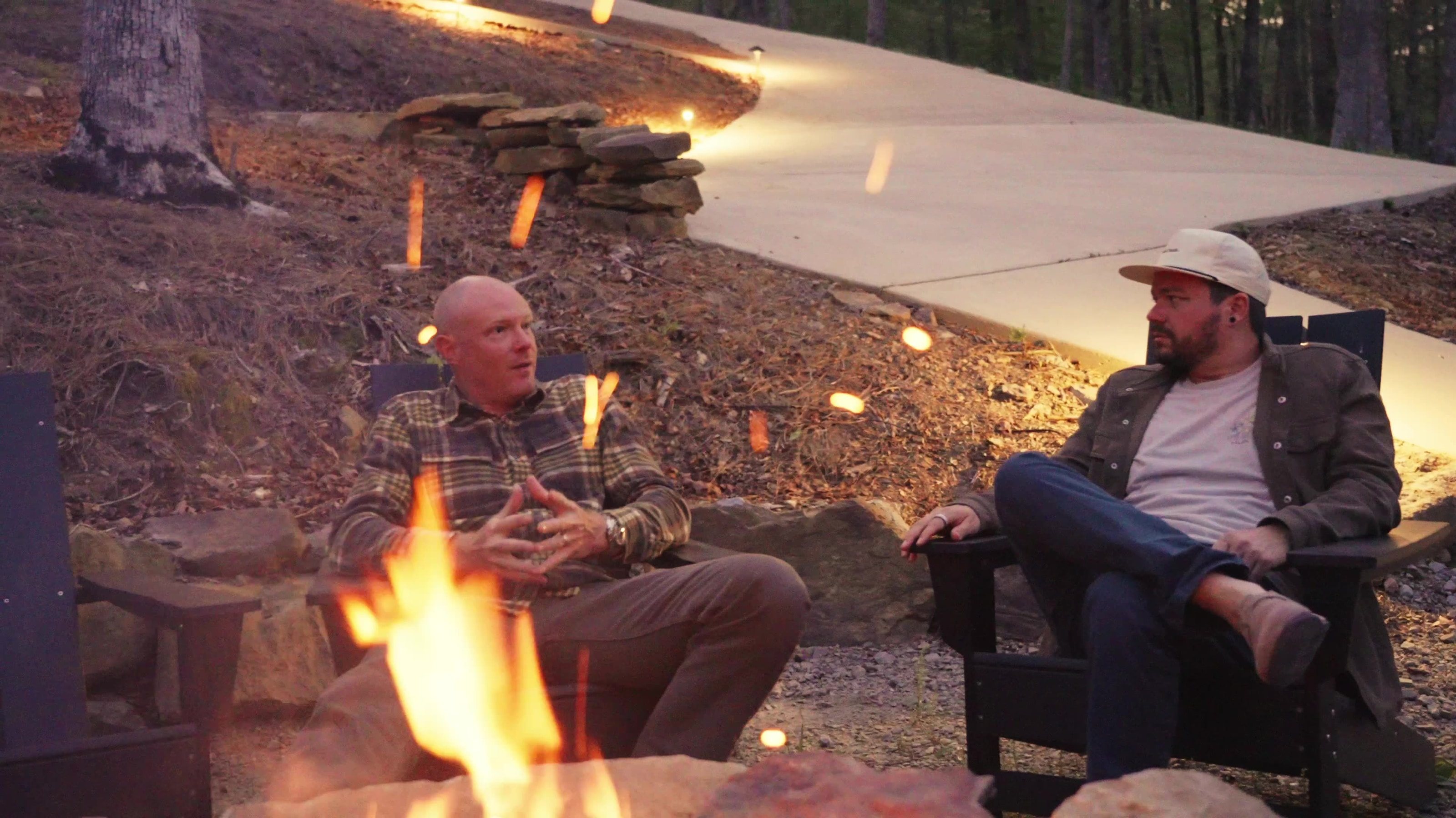 Two of the Sweet Homes friends talking by the fire pit at dusk