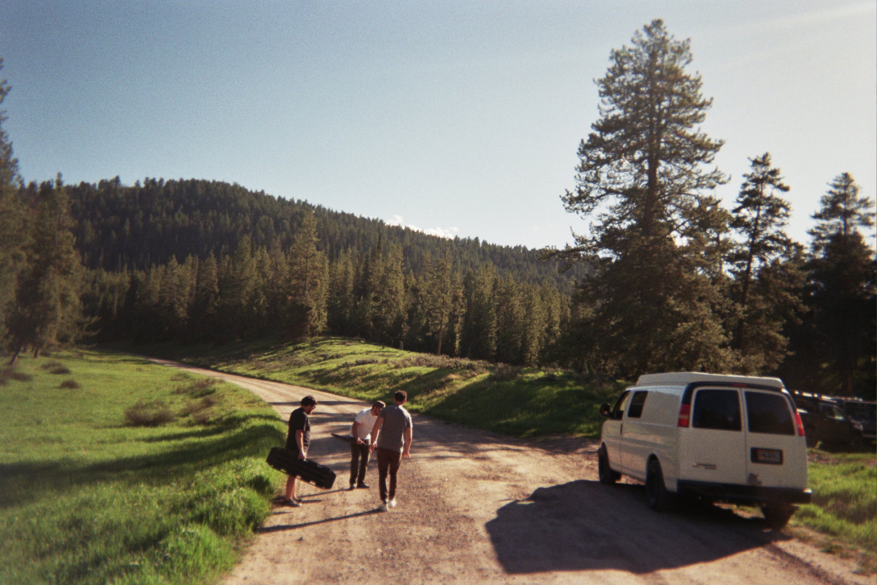 The crew and the van on a dirt road through the pines in Wyoming