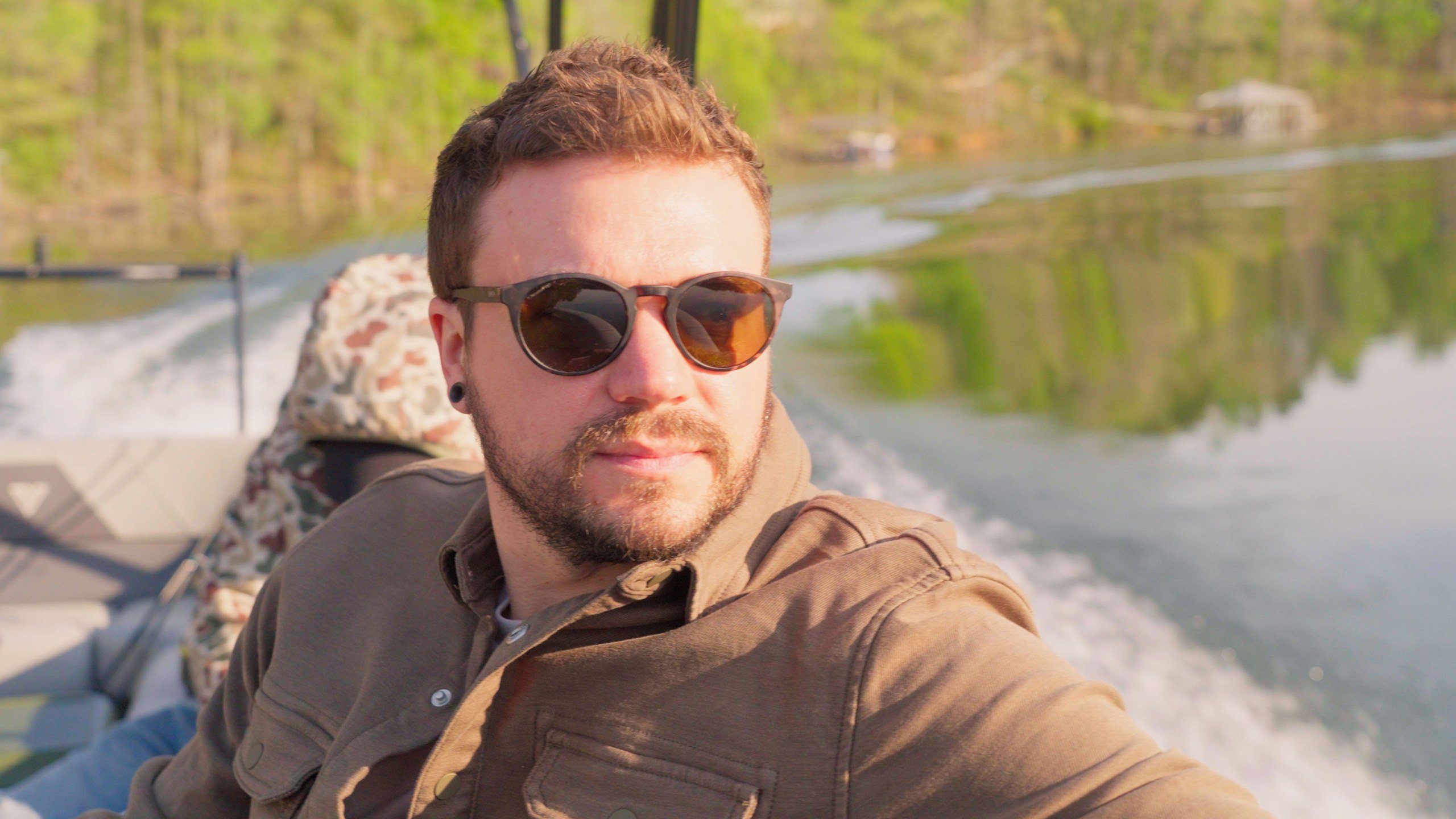 Josh Hemingway in sunglasses on the back of a boat on Smith Lake