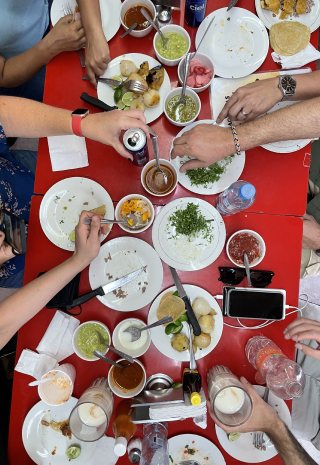 Overhead view of a red table crowded with plates