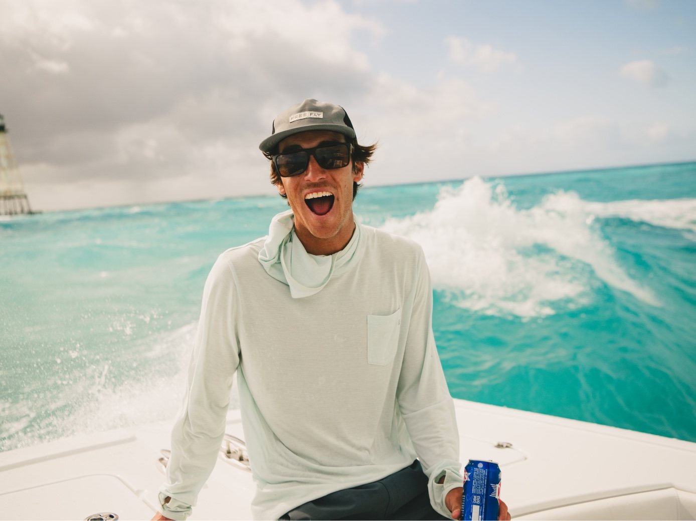 A guide in SMITH sunglasses shouts with joy as spray flies behind the boat