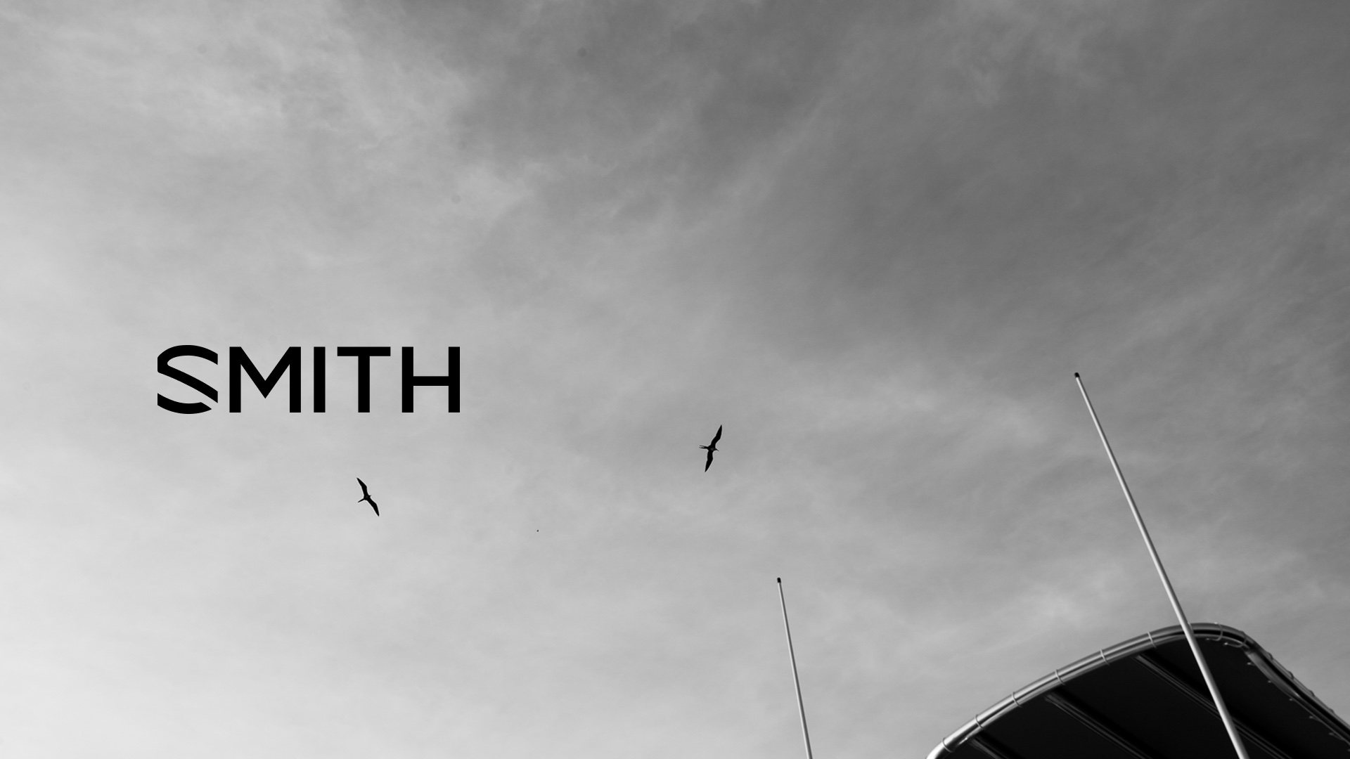 The SMITH logo over a grey sky with birds and the boat's outriggers